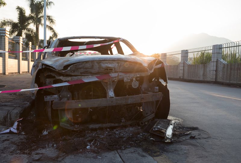 closeup of a burned out car on roadside