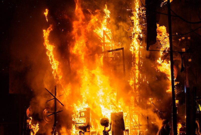 Detail of a Falla Valenciana burning between flames of fire.