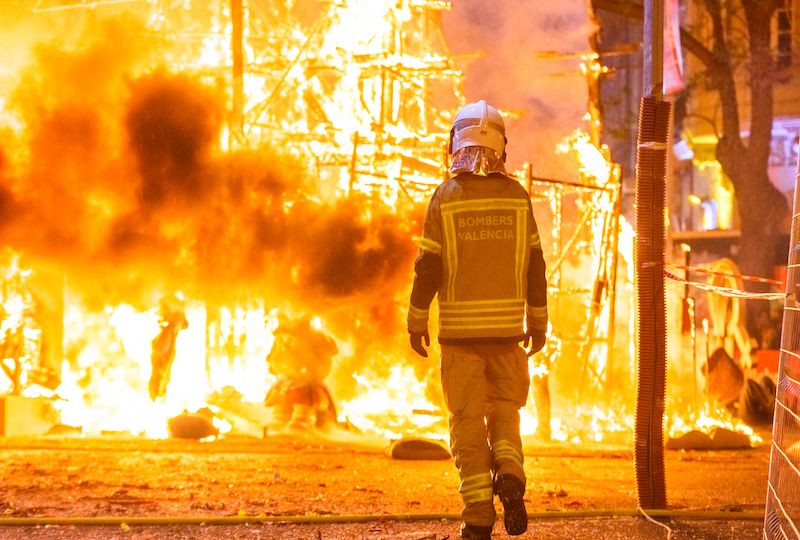 Firefighter with his protective suit working controlling the burning of a Falla during the Valencian fiestas.