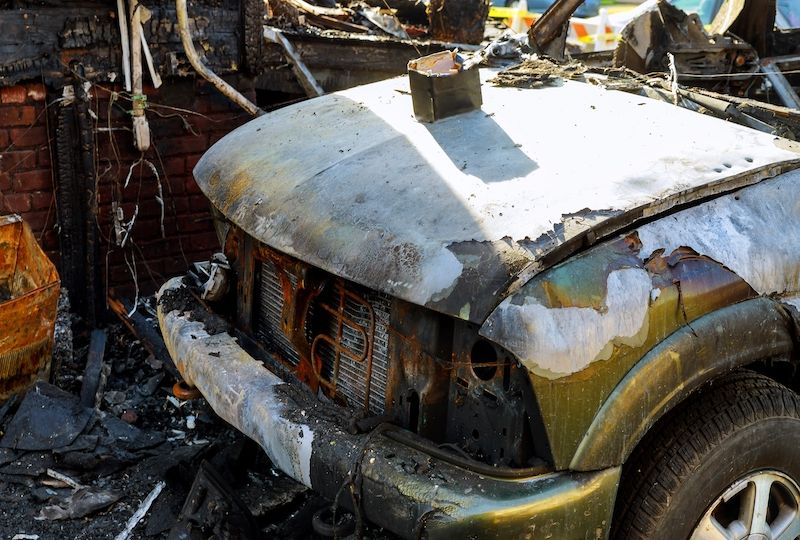 The car after the fire. Burnt out car with an open hood. Engine burned out.