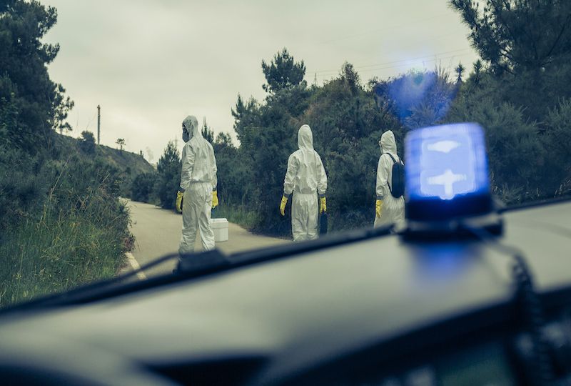 View from emergency car of people with bacteriological protection suits